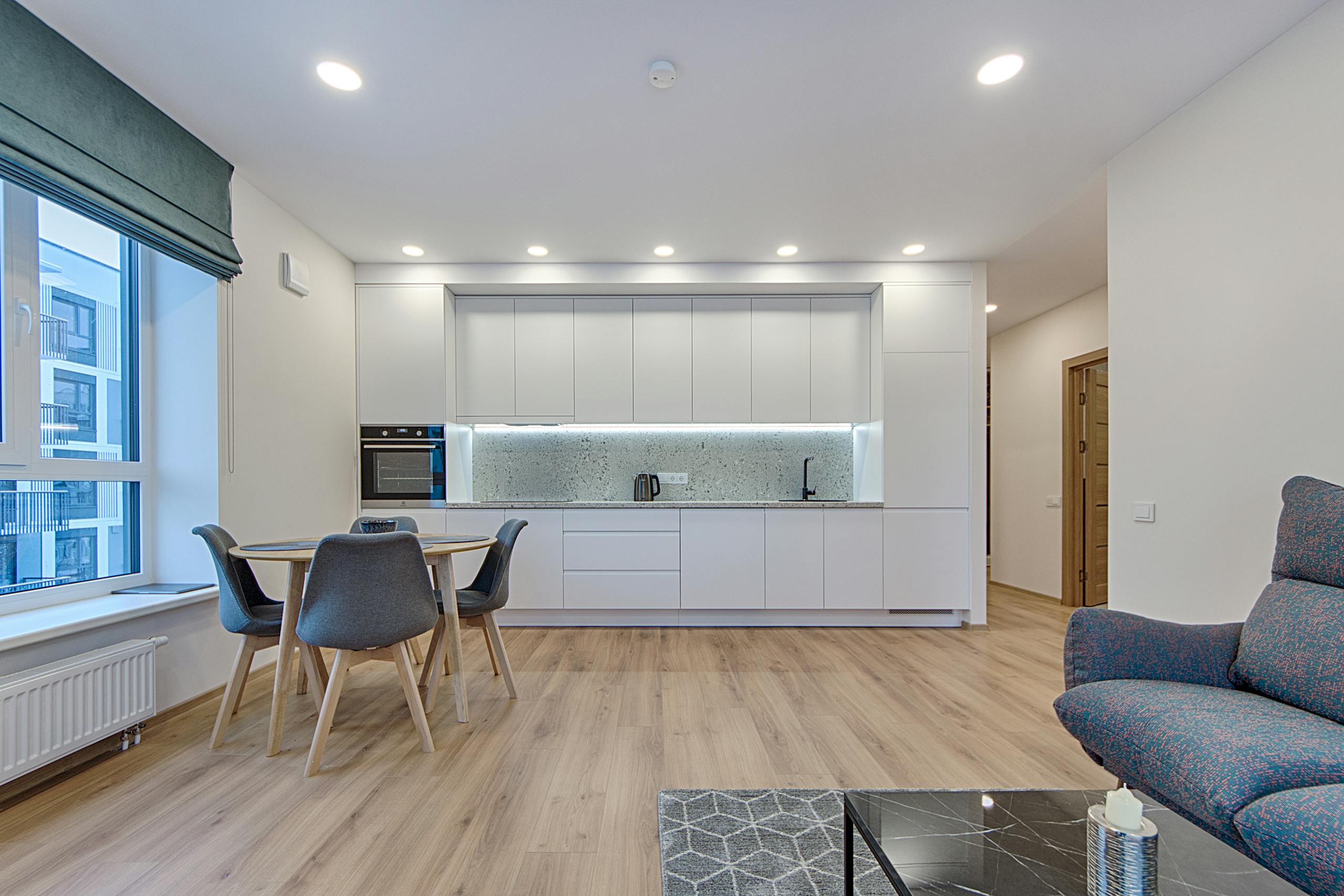Stylish minimalist kitchen and dining area in a contemporary Lithuanian apartment.
